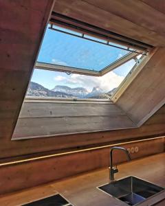a window in a kitchen with a sink and mountains at L'Alpage de la Bergerie apartment in a cosy farmhouse ! in Nâves-Parmelan