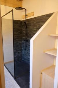 a shower in a room with a brick wall at L'Alpage de la Bergerie apartment in a cosy farmhouse ! in Nâves-Parmelan