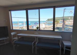 a room with a table and chairs and a large window at Izu no ie MOANA in Ito
