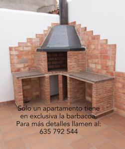 un horno de pizza de ladrillo al aire libre con fogones en Apartamentos Río Guadalaviar, en Albarracín
