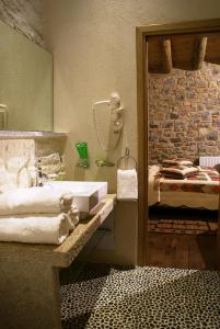 Argyriou Wine Tasting Guest House في بوليدروسوس: حمام مع حوض وسرير