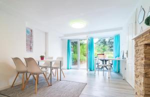 comedor con cortinas azules, mesa y sillas en Cosy and Colorful apartment Szentendre en Szentendre