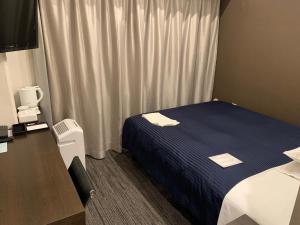 Ochanomizu Inn في طوكيو: غرفة في الفندق مع سرير ومكتب