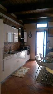 a kitchen with white cabinets and a table and a window at Go home in Tempio Pausania