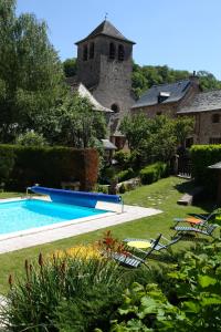 a swimming pool in the yard of a house at Logis Hôtel Restaurant L'Auberge du Chateau in Muret-le-Château
