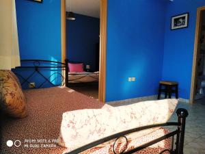 1 dormitorio con 1 cama con paredes azules y espejo en Apartments Onar, en Argostoli