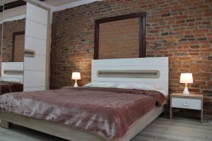 a bedroom with a large bed with a brick wall at MSH Rustic apartment - Liars Bridge Sibiu in Sibiu