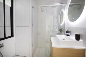 Un baño blanco con lavabo y ducha. en Stylist and cosy appartement in Montparnasse, en París 25 fotos más