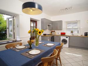 eine Küche mit einem Tisch und einem blauen Tischtuch darauf in der Unterkunft Bela Cottage in Milnthorpe
