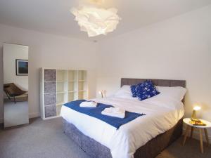 a bedroom with a large bed with blue pillows at Bela Cottage in Milnthorpe