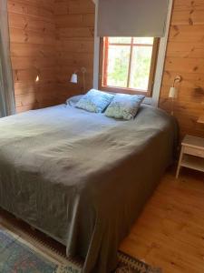 a bedroom with a large bed with a window at Villa Taikuri in Kyläniemi