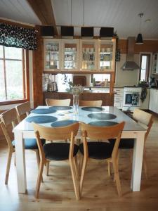 a dining room with a white table and chairs at Villa Taikuri in Kyläniemi