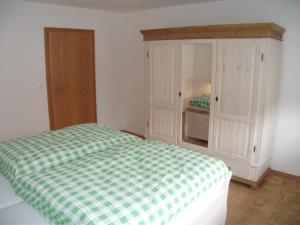 a bedroom with a green and white bed and a cabinet at Ferienwohnung Annemarie in Gernsbach +11 photos