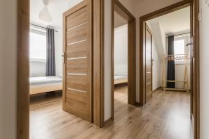 a hallway with two wooden doors and a bedroom at DOMKI BILIKÓWKA in Polańczyk