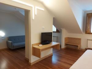 salon z telewizorem i kanapą w obiekcie Hotel - Restaurante Casa Rosita w mieście Cambados
