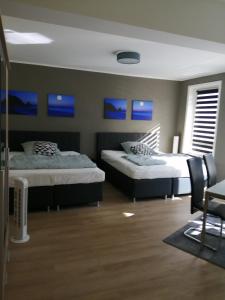 1 dormitorio con 2 camas y cuadros azules en la pared en Fackenburgerapartments en Lübeck