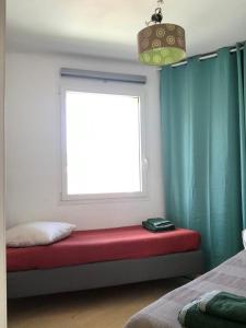 asiento junto a la ventana en un dormitorio con cojín rojo en Vigie - Clim - 4 pers en Cassis