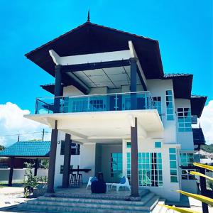 uma grande casa branca com uma grande varanda em Grande Villa CHE Beach House by Vale Pine em Kuala Terengganu