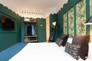 a bedroom with green walls and a bed with pillows at Casa Vaganto in Barcelona