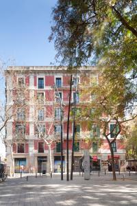 een gebouw op een straat met bomen ervoor bij Casa Vaganto in Barcelona