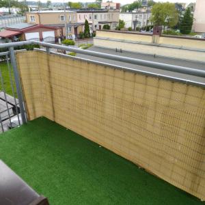 a retaining wall with green grass on a balcony at Centrum - Mala Apartamenty in Wejherowo