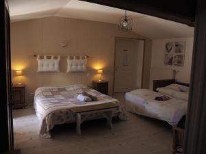 a bedroom with two beds and a table in it at Les Perrières in Saint-Germain-la-Ville