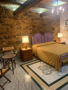 1 dormitorio con cama y pared de ladrillo en B&B Le Casette, en SantʼOnofrio