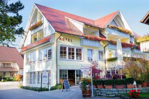 a large white building with a red roof at Hotel Seeperle in Langenargen