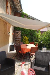 a patio with a table and chairs and an umbrella at Les Perrières in Saint-Germain-la-Ville +9 photos