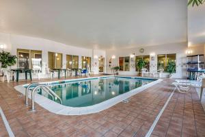 una piscina en un hotel con sillas y mesas en Comfort Suites Cincinnati Airport, en Hebron