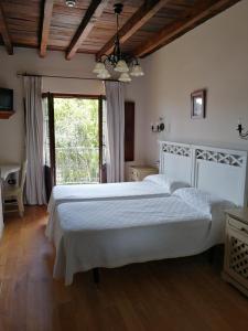 Un dormitorio con una gran cama blanca y una ventana en Posada El Jardin de Angela, en Santander