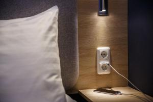 un mando a distancia en una mesa junto a la cama en Holiday Inn Express Frankfurt Airport, an IHG Hotel, en Mörfelden-Walldorf