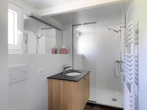 a white bathroom with a sink and a shower at Alpenheim in Teufen