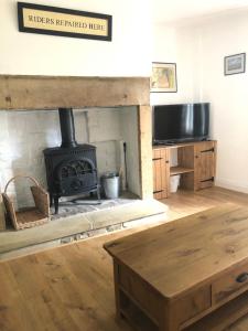 a living room with a fireplace and a stove at Mole Cottage in Stocksfield