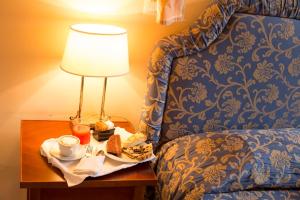 a table with a lamp and a plate of food on a bed at Palazzo Guiderocchi in Ascoli Piceno