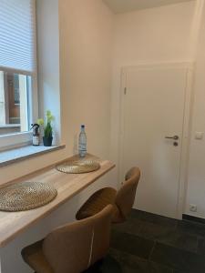 Cette chambre dispose d'un comptoir avec deux chaises et d'une fenêtre. dans l'établissement Romantic Bohemian Apartment Adenau, Center, Nahe Nürburgring, à Adenau