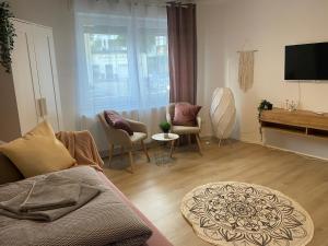 a living room with a couch and chairs and a television at Rooms4ring UG Romantic Bohemian Apartment Adenau in Adenau