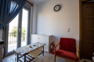 a room with a table and a chair and a clock at Pyrgos Sofokleous in Mytilene