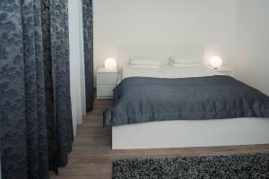 ein Schlafzimmer mit einem Bett mit einer schwarzen Tagesdecke in der Unterkunft Laurentroom Central Park in Ukmergė
