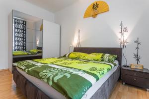 een slaapkamer met een groot bed met gele en groene lakens bij Jet Hottub - Washer&Dryer - 12min Center - 160MBs WIFI in Praag