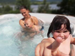 a woman and two men in a swimming pool with a baby at VN Ľuboreč - Rekreačná chata in ľuboreč