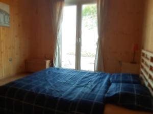 a blue bed in a room with a window at VN Ľuboreč - Rekreačná chata in ľuboreč