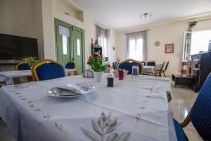 a dining room with a long table with blue chairs at Pyrgos Sofokleous in Mytilene