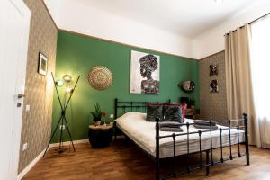 sypialnia z łóżkiem i zieloną ścianą w obiekcie Zur Linde w Sybinie