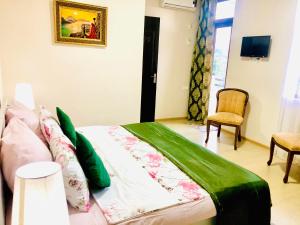 a bedroom with a bed with a green comforter at Holiday House Green Cape Batumi in Mtsvane Konts'khi
