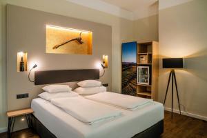 Un pat sau paturi într-o cameră la Hotel Rathaus - Wein & Design