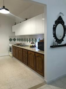 a kitchen with wooden cabinets and a mirror on the wall at résidence les oliviers in Soliman +11 photos