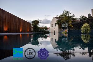 a pool of water in front of a building at Volcanic Charming House in Ribeira Grande