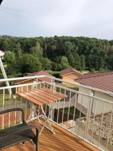 a deck with a table and a bench on a balcony at Carolinger Hüttendorf in Weyer