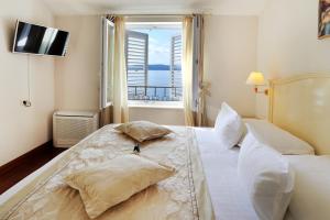 a bedroom with a large white bed with a window at Hotel Sunceva Postelja Brela in Brela